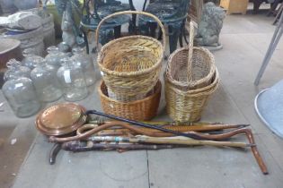Assorted walking sticks, a warming pan and five wicker baskets
