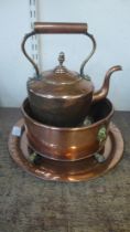 A Victorian copper kettle, a bowl, a small charger and a brass trivet