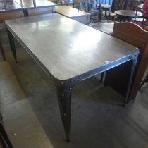 A large industrial style polished steel kitchen table