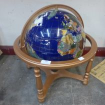 A semi-precious gemstone inlay terrestrial globe on coated brass stand