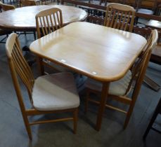 A teak extending dining table and four chairs