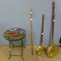 A small glass topped folding occasional table, two brass warming pans and a walking cane