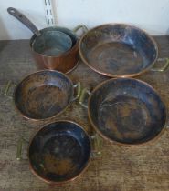 Two small copper saucepans and a set of four copper and brass handled dishes