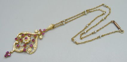 A 15ct gold Art Nouveau drop pendant set with rubies and seed pearls, 5.8cm including bale and drop,