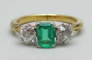 A yellow metal ring set with a central emerald and two diamonds, 3.8g, Q/R, emerald 5mm x 7mm, shank