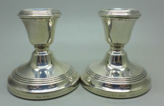 A pair of silver dwarf candlesticks, weighted bases