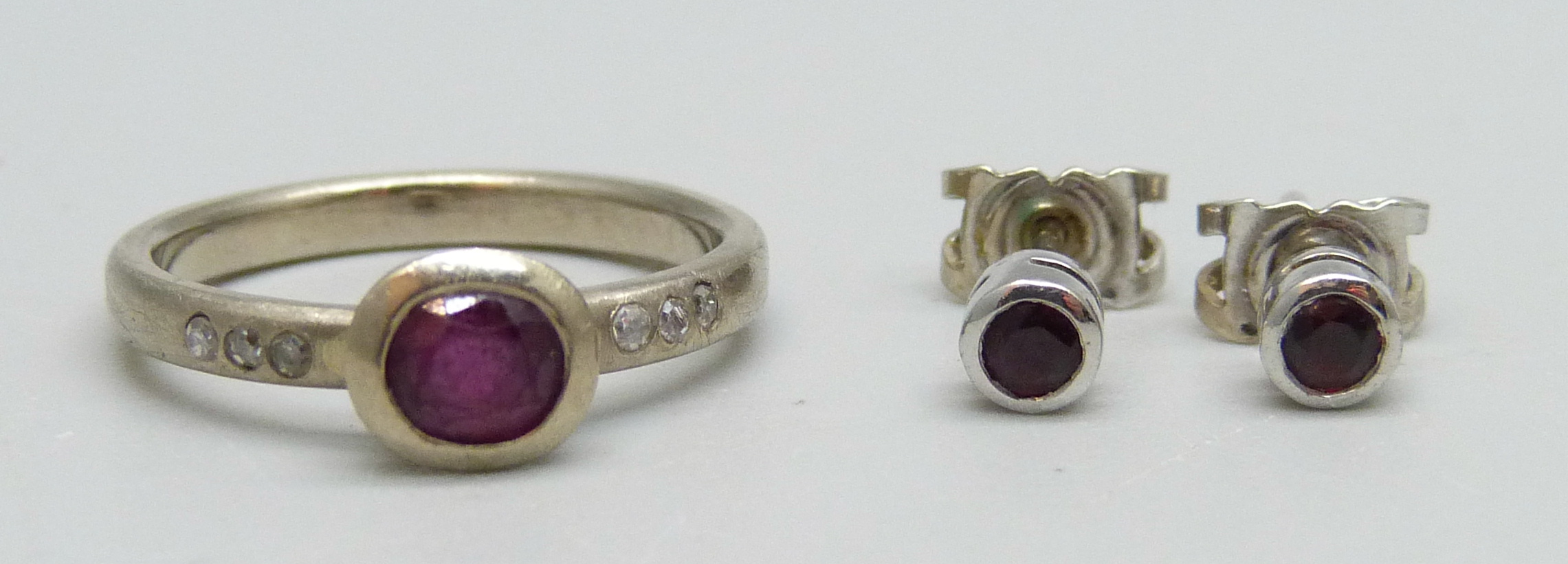 A 14ct white gold, diamond and ruby ring, M, and a pair of 18ct white gold and ruby stud earrings,