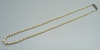 A cultured pearl necklace with a white metal five stone diamond clasp, circa 1930, approximately