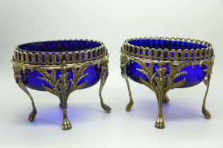 A pair of Victorian silver oval table bon-bon dishes on four feet and with blue glass liners, London