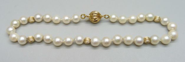 A pearl bracelet with a gold clasp marked 14k, and gold beads, 7g, approximately 20.5cm