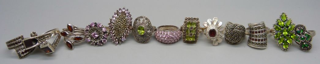 Twelve large chunky silver rings set with garnet, pearl and peridot, and one unmarked white metal