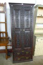 A George III carved oak two door housekeeper's cupboard