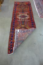 An Iranian red ground runner rug, 306 x 99cms
