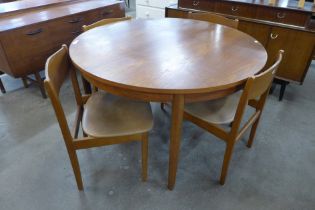 A teak circular extending dining table and four chairs