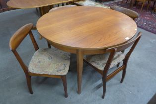 A teak circular extending dining table and four chairs