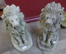 A pair of concrete garden figures of seated lions