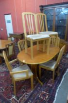 A teak oval extending dining table and six chairs