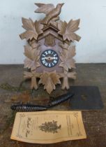 A Black Forest beech and faux wood cuckoo clock