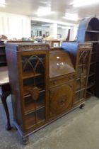 An early 20th Century carved oak side by side bureau bookcase