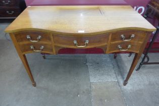 An Edward VII mahogany five drawer serpentine writing table