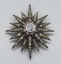 A circa 1900 diamond set starburst pendant/brooch, centre stone approximately 0.75 carat diamond