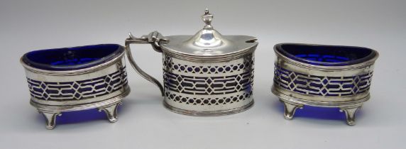 A silver three piece cruet set with blue glass liners, Chester 1916; a pair of salts and mustard,