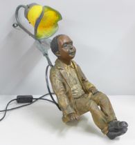 A resin lamp with glass shade, depicting a seated boy