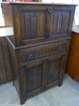 A carved oak linenfold cocktail cabinet