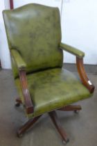 A mahogany and green leather revolving desk chair
