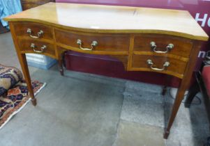 An Edward VII mahogany five drawer serpentine writing table