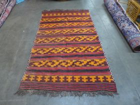 A red, orange and black rug, 252 x 145cms