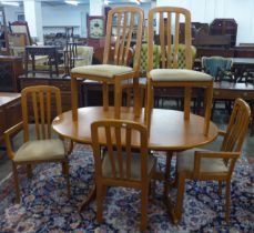A teak oval extending dining table and six chairs