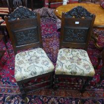 A pair of early 20th Century carved oak hall chairs