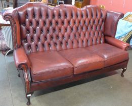 A Chesterfield red leather wingback settee