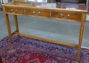 A yew wood three drawer console table