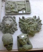 Two concrete gargoyles, welcome sign, lion and a skull