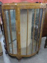 An Art Deco walnut serpentine single door display cabinet