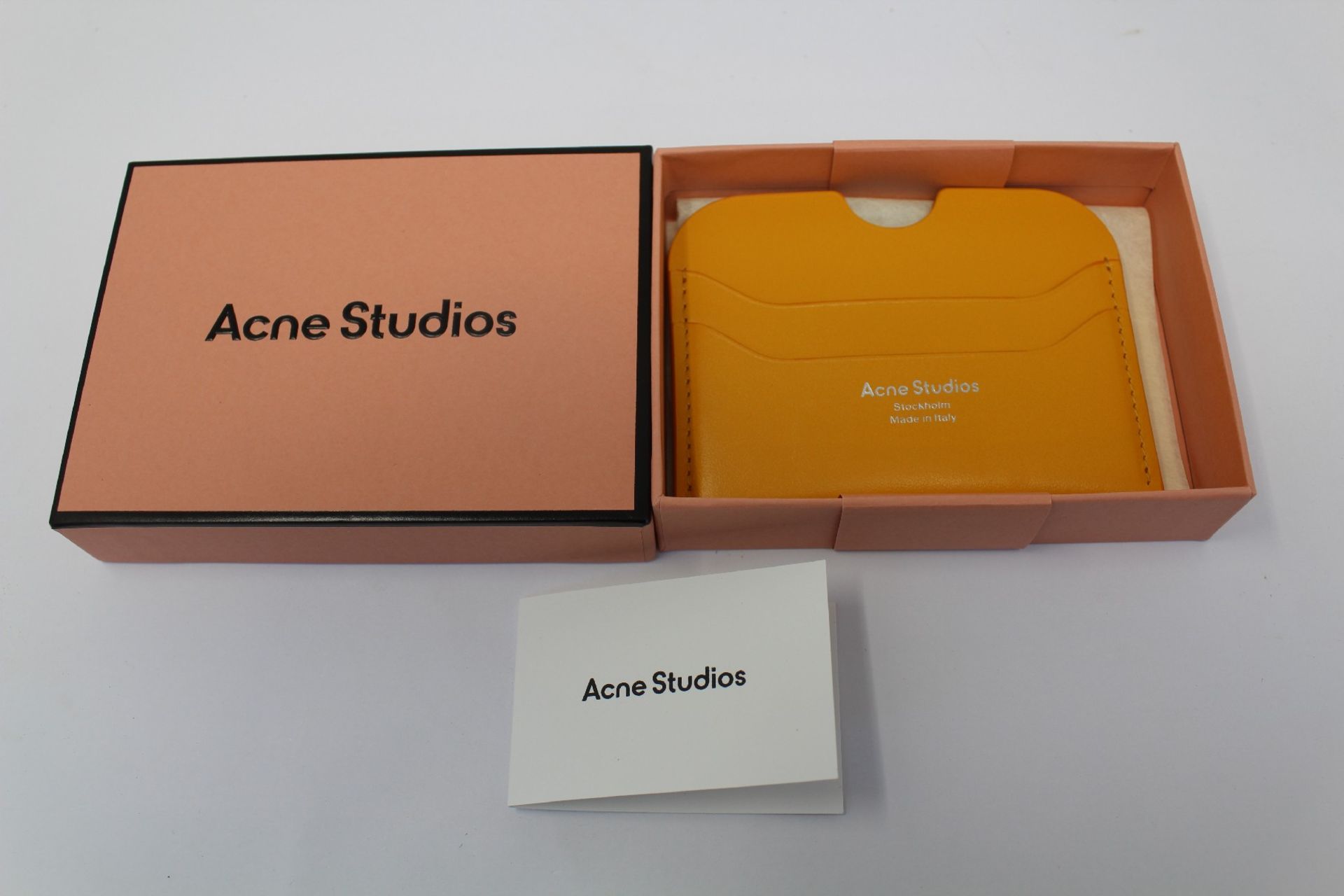 A boxed as new Acne Studios Leather Card Holder in Pumpkin Orange.