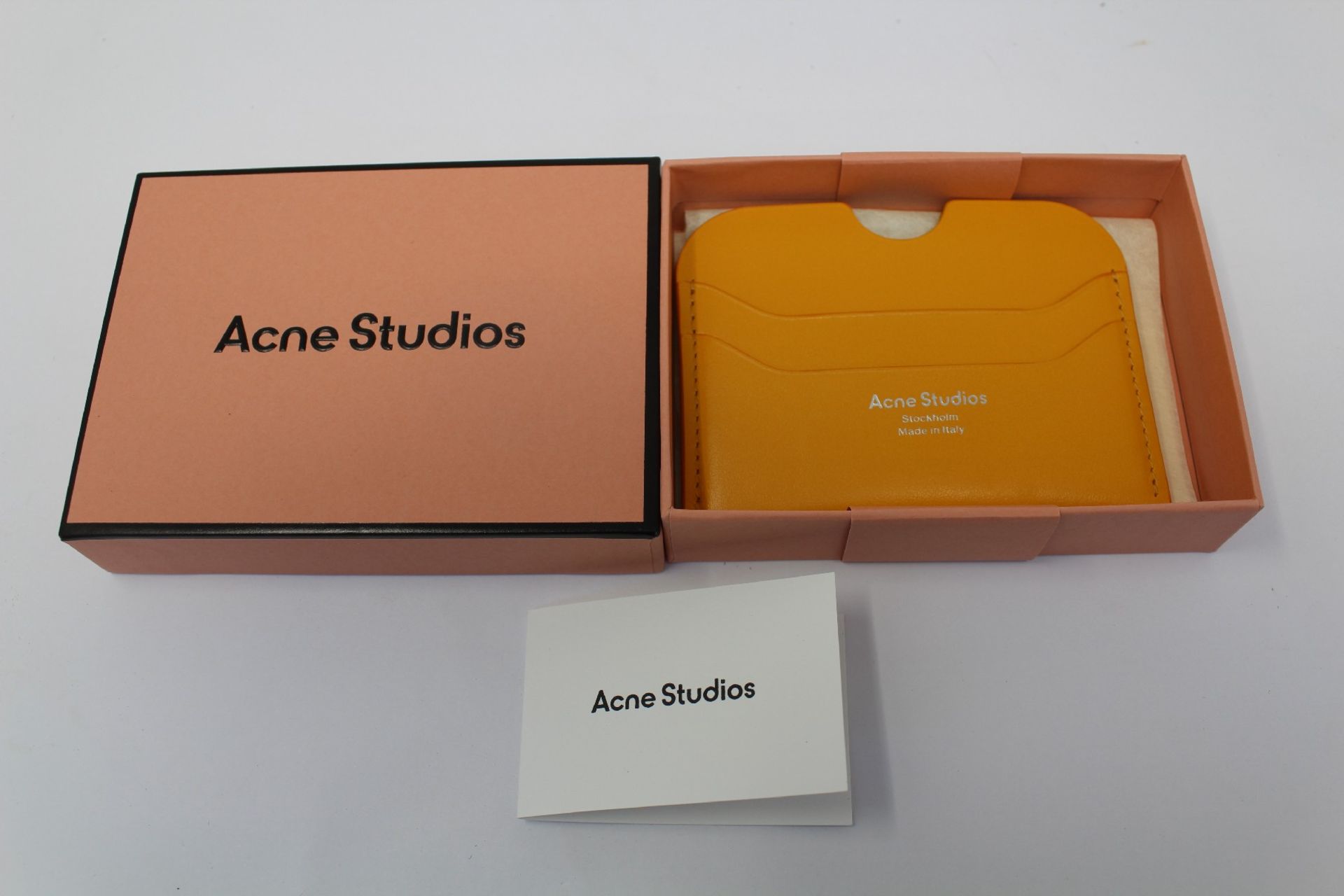 A boxed as new Acne Studios Leather Card Holder in Pumpkin Orange.