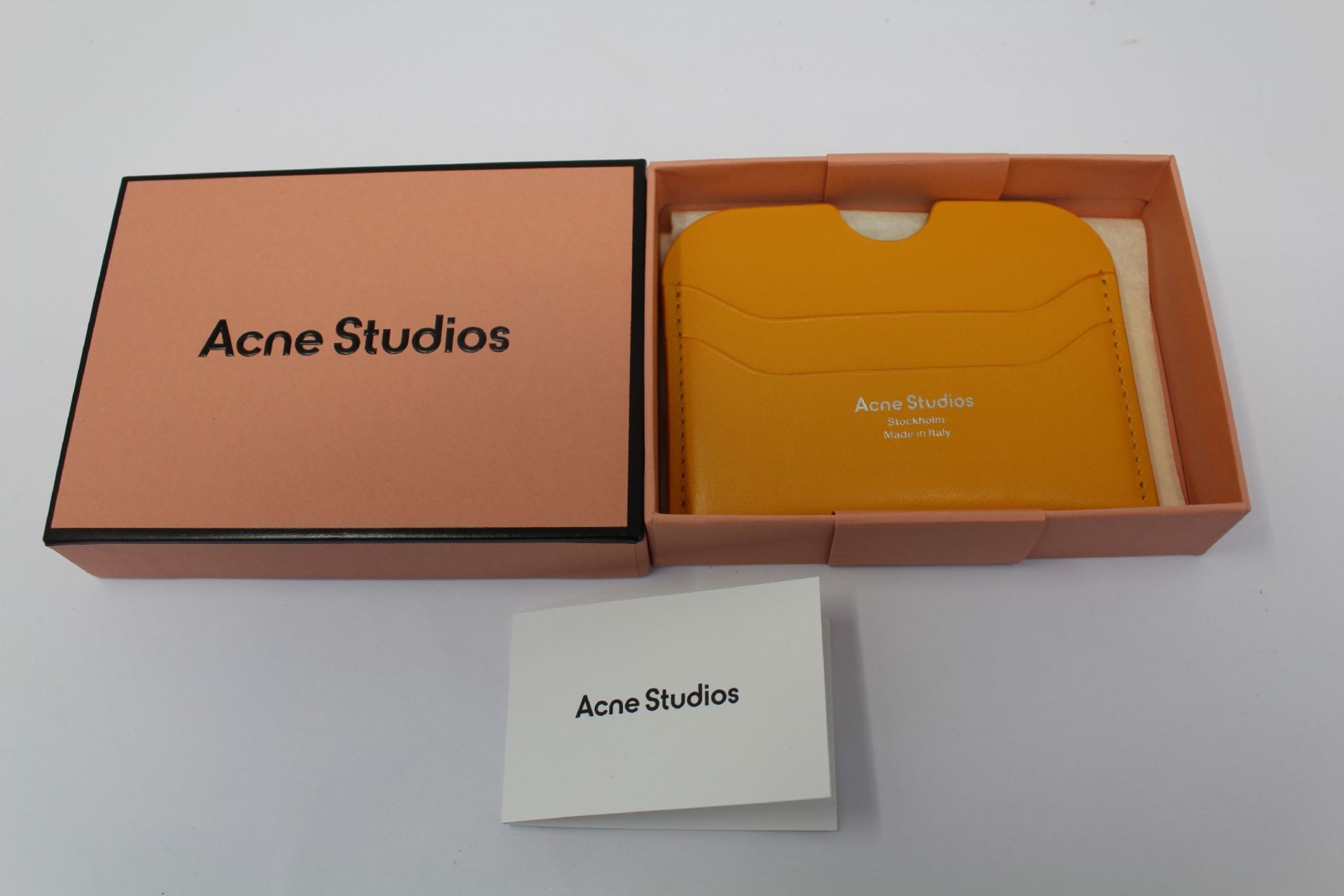 A boxed as new Acne Studios Leather Card Holder in Pumpkin Orange.