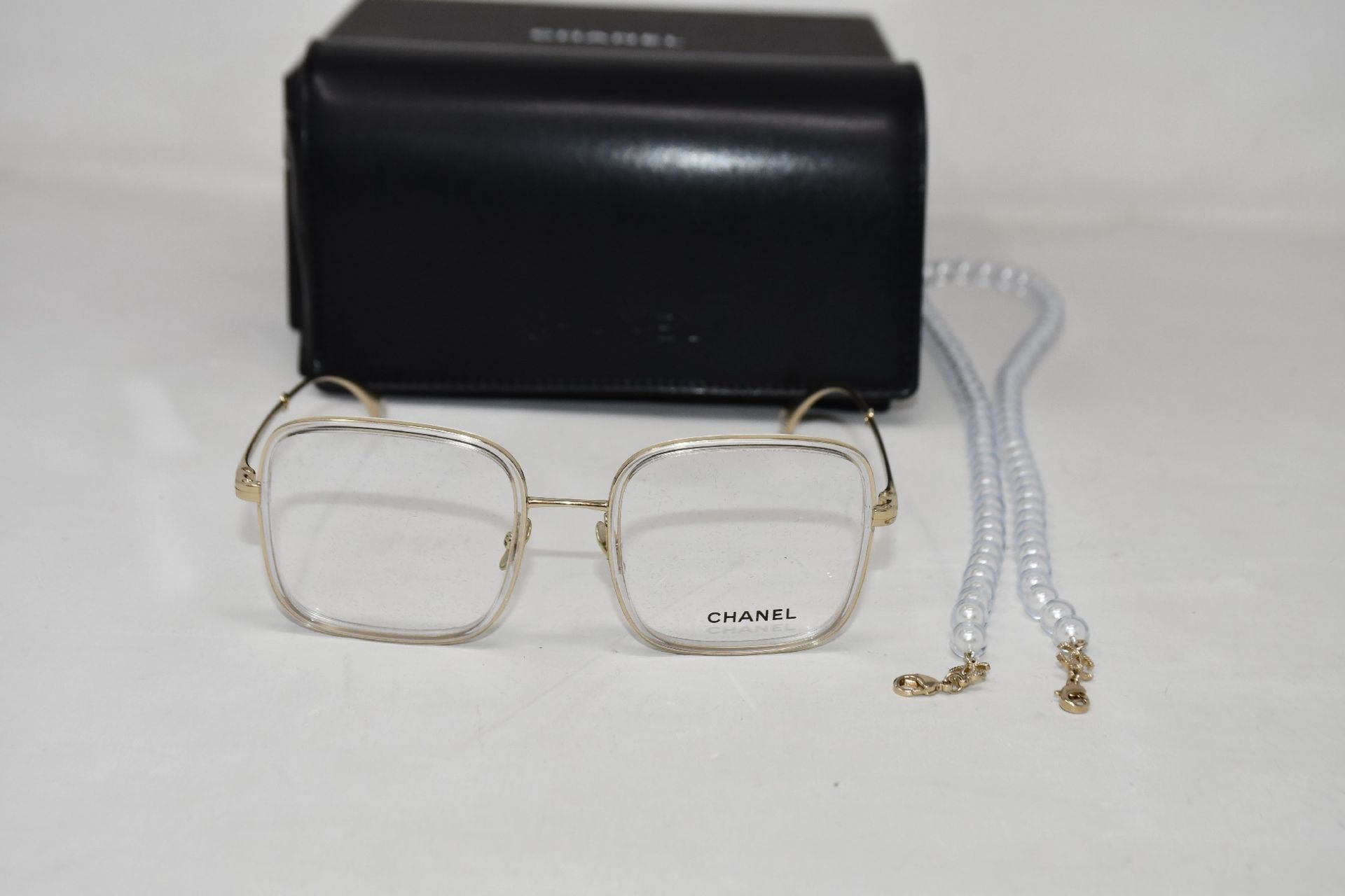 A pair of pre-owned Chanel 2195 Square Lens Eyeglasses with a Glass Pearl Glasses Chain, Comes