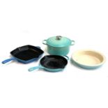Two Le Creuset cast iron skillets, together with a cast iron saucepan with lid and a stoneware dish,