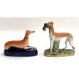 A pair of Staffordshire long dog figurines, one holding quarry (af), 19cmH