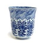 A Chinese blue and white cup decorated with floral panels, marked to base with a flower in double