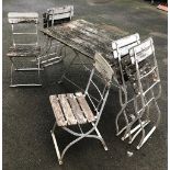A white painted garden table and six folding chairs