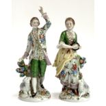 A pair of Sitzendorf figures, a lady and gentleman, each with lamb, 20cm and 22cmH