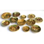 A collection of 12 decorative wall hanging chalkware cottage plates, one signed E.W Usher