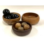 Three turned wooden bowls, the largest 25cmD; together with four carved wooden apples, and four