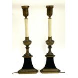 A pair of gilt metal table lamps in the form of candle holders, on triangular bases, 59cmH