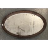An oval wall mirror in moulded oak frame, 80x50cm